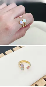 Détail d'une bague dorée ajustable avec points émaillés rose, violet, vert et bords striés