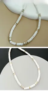 Détail d'un collier de perles bohème avec disques blancs et perles d'espacement dorées