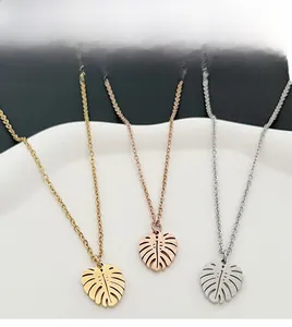 Détail de pendentifs feuille en or, argent et or rose sur chaînes fines épurées