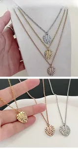 Détail de pendentifs feuilles de monstera tricolores en finitions or, argent et rose