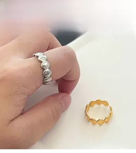 Detail of seashell rings in gold and silver showing realistic fan-shaped textures