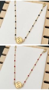 Detail showing gold Tai Chi Yin Yang pendant bracelets with black and red beads