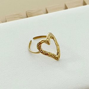 Adjustable gold heart ring with hammer texture finish on a white leather pad