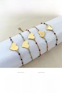 Detail view of five gold-plated heart charm bracelets with multi-colored enamel beads