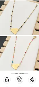 Detail of gold heart pendant bracelets with colorful beads and care instruction icons
