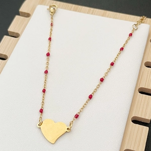 Golden stainless steel chain bracelet with red beads and a smooth heart-shaped pendant