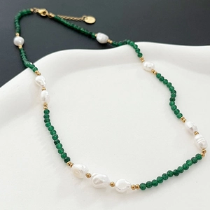 Collana fatta a mano con perle barocche e pietre verdi su un vassoio bianco