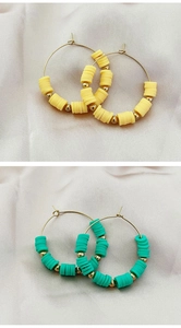 Detail of bohemian hoop earrings with colorful heishi beads in yellow and turquoise