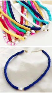 Detail of bohemian colorful heishi clay bead necklaces with irregular white pearls