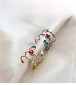 Detailed shot of gold and silver heart and moon rings on soft beige silk fabric