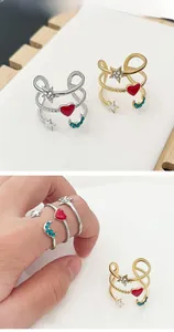 Detail of adjustable star and heart rings in gold and silver with colorful enamel