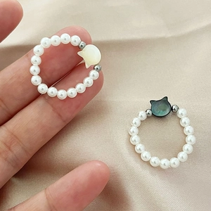 Cat-themed set of two pearl rings featuring white and black mother of pearl cat motifs