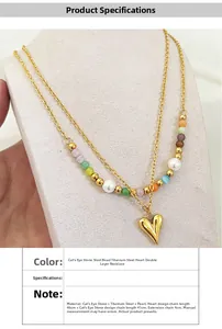 Detail of double-layer titanium necklace with cat eye stones pearls and golden heart