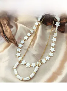 Macro view of vintage beaded necklace with white stars on champagne silk fabric