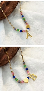 Close-up of colorful beaded necklace with golden heart and letter A and B pendants