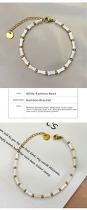 Détail de perles en nacre blanche en forme de bambou et chaîne en acier inoxydable doré