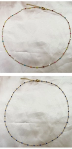 Macro detail of gold stainless steel necklaces with colorful and blue seed beads
