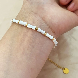 Bracelet pour femme avec perles en nacre blanche style bambou et acier titane doré