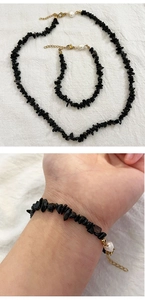 Detail of vintage necklace set with irregular black stones and single white pearl accent