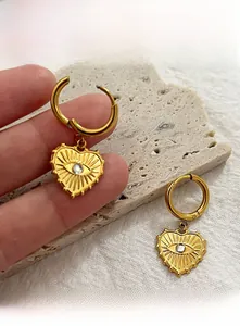 Detail von goldenen Herz-Augen-Ohrringen mit Kristalleinlage auf Steindisplay