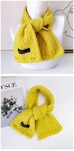 Gros plan d'une écharpe en maille jaune vif avec motifs torsadés et détail de bouton