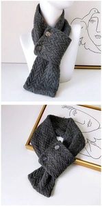 Détail de la maille d'une écharpe gris foncé avec fermeture décorative à double bouton