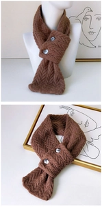 Gros plan sur la maille torsadée marron café et le détail des boutons de cette écharpe