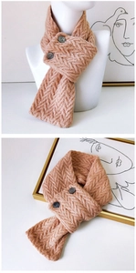 Détail de la maille torsadée et des boutons sur une écharpe d'hiver rose abricot