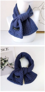 Détail d'une écharpe en maille bleue avec étiquette tissée et texture douce et épaisse