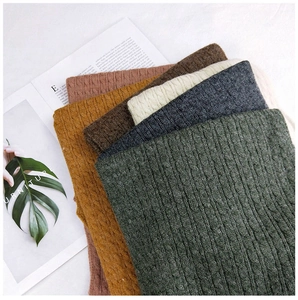 Detailed macro view of various colors and thick cable knit texture of winter scarves