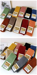 Detailed grid showing vibrant colorful knitted scarves with Good Luck label tags