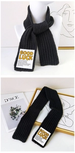 Close-up of black knit scarf with vertical stripes and GOOD LUCK motivational label