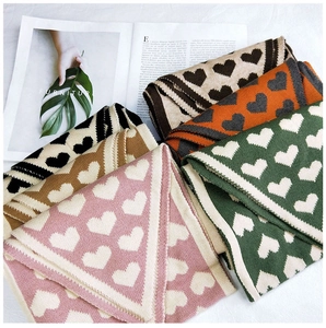 Détail de la maille de foulards à motifs de cœur en plusieurs couleurs empilés avec soin