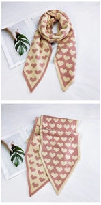 Détail de l'écharpe en maille rose avec motifs cœurs et finitions triangulaires