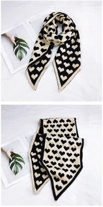 Détail de l'écharpe en tricot à motifs de cœur avec des extrémités en V