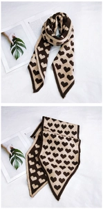 Détail de l'écharpe en tricot à motif cœurs avec pointes en marron foncé et beige