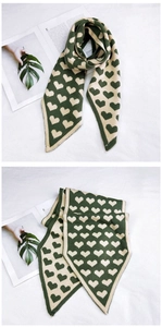 Détail du motif cœur et des pointes triangulaires d'une écharpe en maille verte