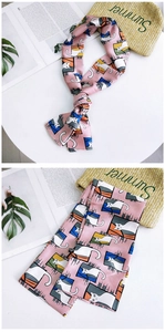 Detailed macro view of pink silk scarf with cartoon cat prints and geometric patterns