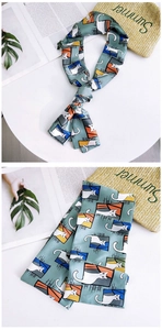 Detail of skinny scarf with whimsical cat and window pattern on soft green silk