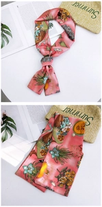 Detail of pink floral silk scarf featuring tropical prints and artistic portraits