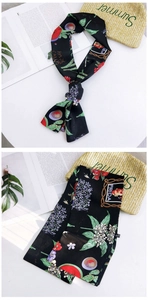 Detail of artistic narrow black silk scarf with vibrant Frida Kahlo style floral patterns