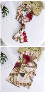 Detail of pink and burgundy long silk scarf with golden chain and key patterns