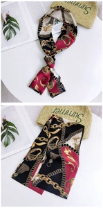 Detail of silk-like neckerchief with retro gold chain patterns and sleek satin texture