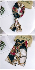 Detail of narrow silk scarf with vintage chain print and elegant buckle pattern