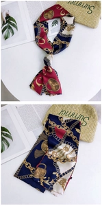 Detail of vintage skinny scarf with golden chain patterns and nautical silk print