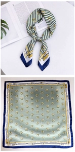 Detail showing green striped silk scarf with gold equestrian chain pattern and blue border