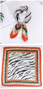 Detail of silk scarf with orange and green borders featuring zebra and leopard prints