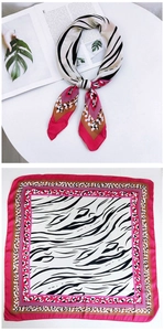 Detail view of square silk scarf with zebra print patterns and bright pink borders
