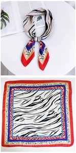 Detailed pattern of a square silk scarf with zebra print, leopard spots and bold red borders