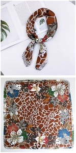 Detailed pattern of silk scarf featuring giraffe print, floral accents, and zebra textures